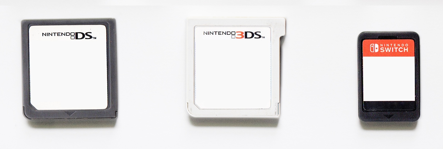 Nintendo DS, Nintendo 3DS, and Nintendo Switch game cards arranged from left to right.